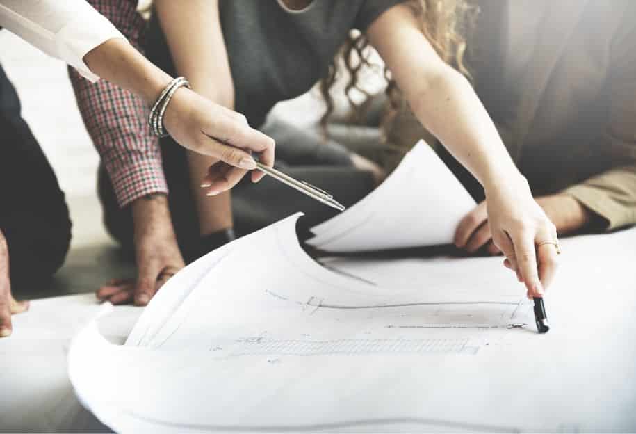 People discussing blueprint designs